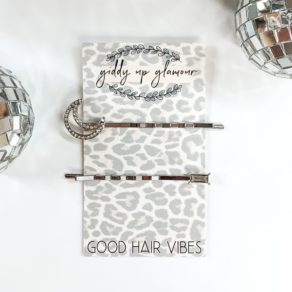 silver hair pins; one with a moon and one with a baguette
