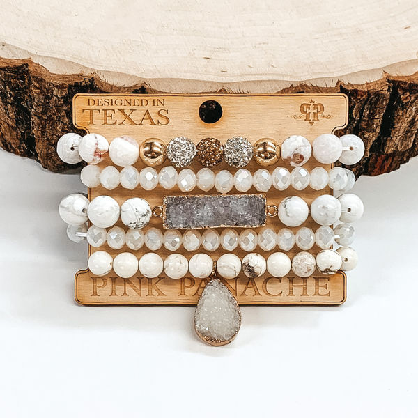 white crystal beaded bracelets, white marbled beaded bracelets, some includes silver and gold beads; one bracelet has a grey druzy rectangle bar and another bracelet has a grey druzy teardrop charm