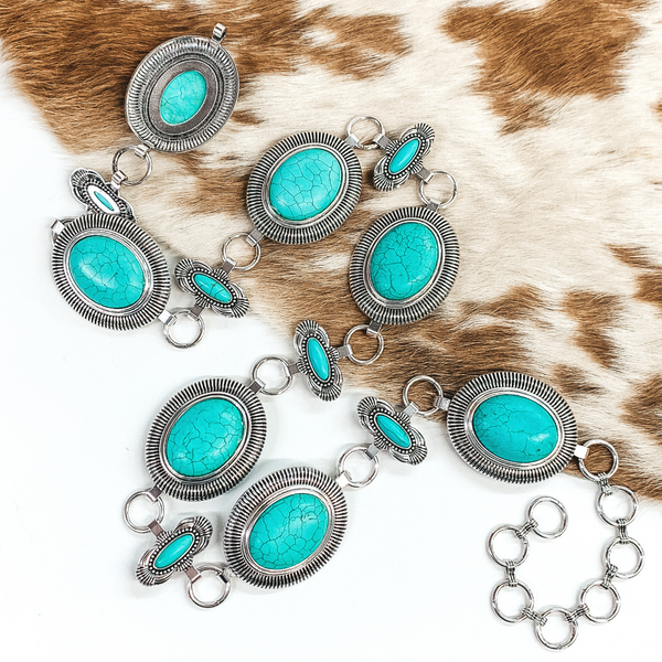 Silver concho belt with big center stones and small oval spacers. This belt has tiny circle loops to make it adjustable. This belt is pictured on a white background. 