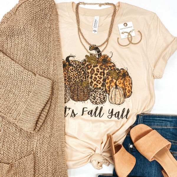 Beige crew neck tee shirt with leopard pumpkins that says "It's Fall Y'all" Underneath. Picured with tan cardigan, jeans, block heels, and gold jewelry.