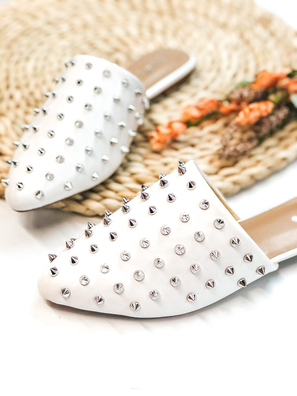 Uptown Girl Silver Spiked Slide On Mules in White. These cute shoes will give you an uptown flare! They include a silver spike embellished upper, a pointed toe, and a 0.25 inch high heel. Pair these shoes with any outfit for a fun look!