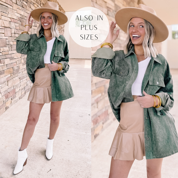 Model is wearing a button up corduroy shacket in olive green. Model has it paired with a white top, mini skirt in taupe, white booties and gold jewelry. 