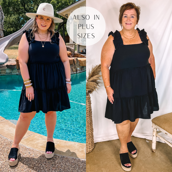 Models are wearing a short black babydoll dress with ruffle tank straps. Size small model has it paired with white heels and gold jewelry. Size large model has it paired with black wedges, gold jewelry, and a beige hat.