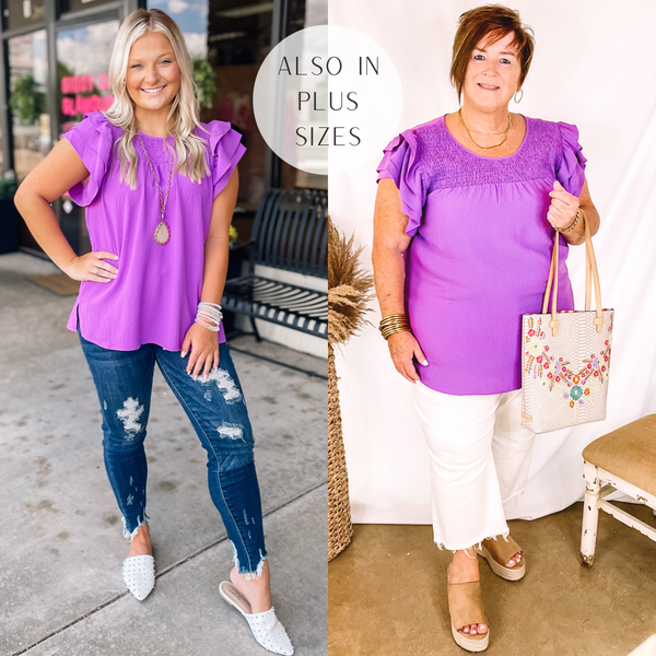 Model is wearing a purple ruffle cap sleeve top with a smocked upper. Model has this top paired with distressed dark wash skinny jeans, white mules, and gold jewelry.