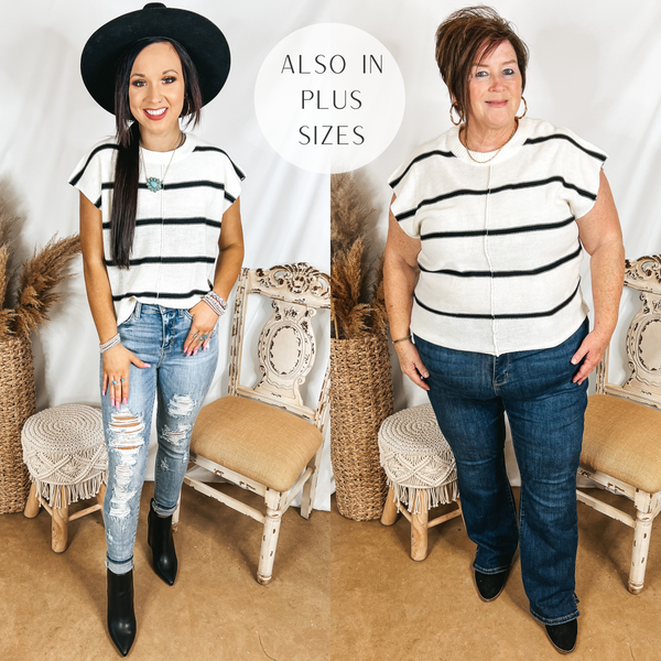 Models are wearing a striped short sleeve sweater. Size small model has this ivory and black top paired with distressed skinny jeans, a black hat, and black booties. Plus size model has it paired with bootcut jeans, black booties, and gold jewelry.