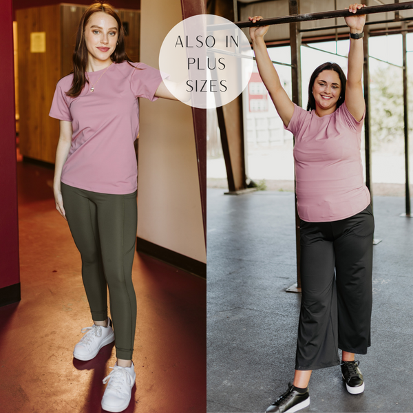 Models are wearing a mauve pink active top that has short sleeves. Size small model has it paired with olive green leggings and white sneakers. Size large model has it paired with black sweatpants and black sneakers.