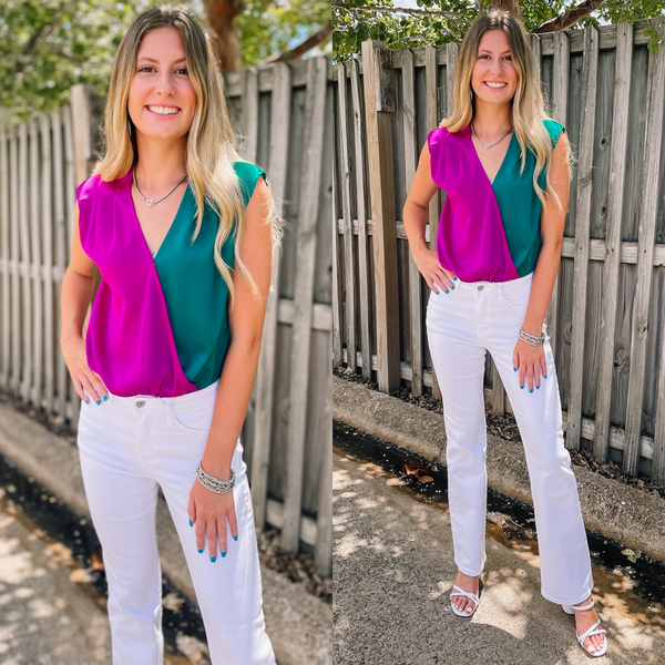 Model is wearing a half magenta purple, half teal green bodysuit. Model has it paired with white jeans and white heels.