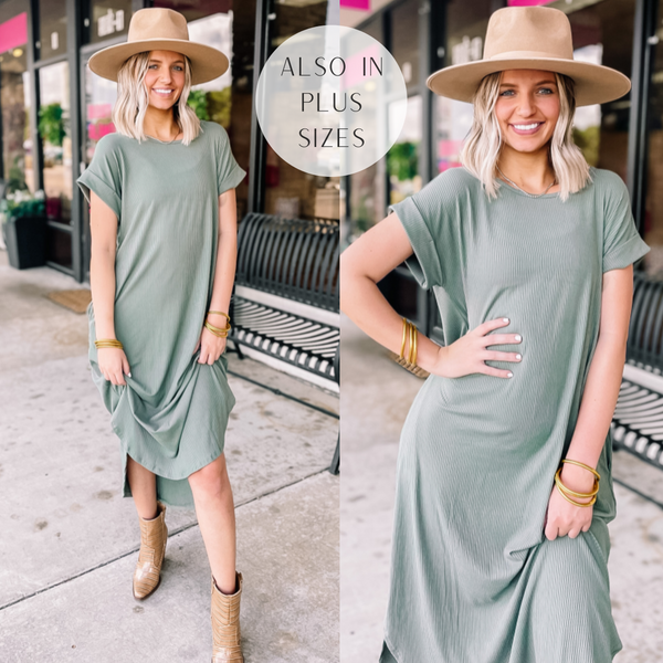 Model is wearing a short sleeve, ribbed midi dress in light green. Model has it paired with tan booties, a tan hat and gold jewelry. 