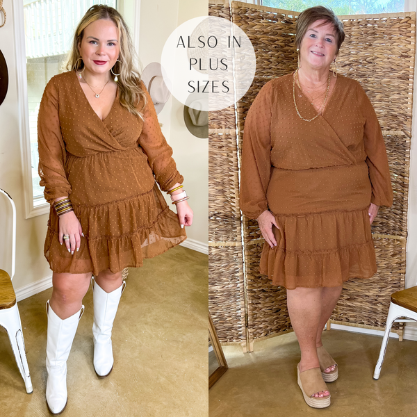 Model is wearing a camel brown swiss dot dress with long sleeves. Model has it paired with white boots and gold jewelry.