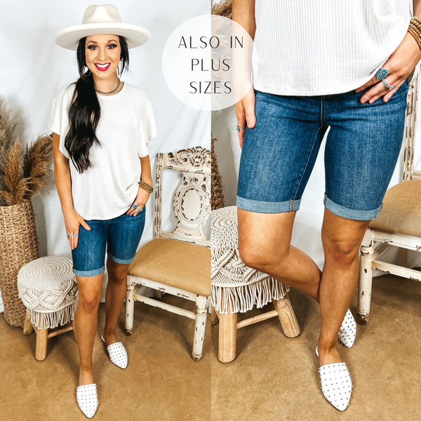 Models are wearing a cuffed Bermuda shorts. Model has it paired with a white top, white mules, and an ivory hat.