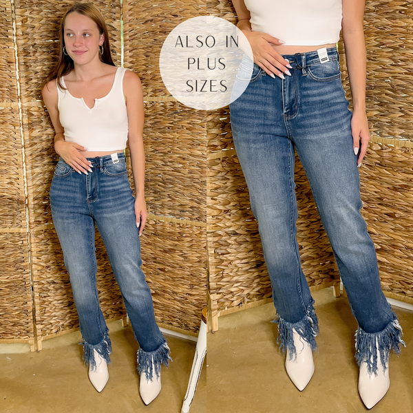 Model is wearing a pair of slim fit jeans with a frayed hem. Model has it paired with white booties, a white tank top, and gold hoop earrings.