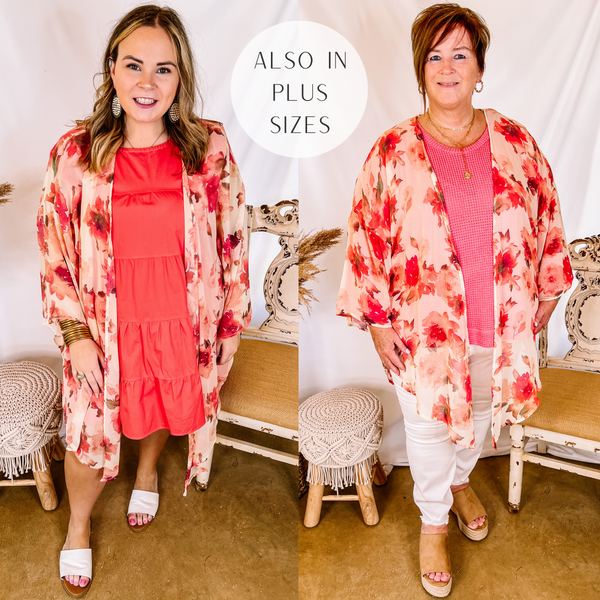 Models are wearing a pink floral print kimono. Size large model has it on over a coral dress with white sandals and gold jewelry. Plus size model has it on over a pink top and white skinnies with tan wedges and gold jewelry.