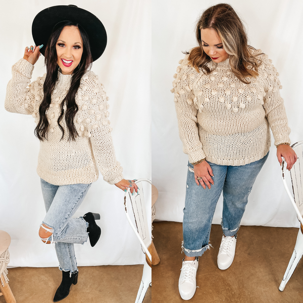 Models are wearing an ivory long sleeve sweater that has a puff ball upper. Size small model has it paired with light wash jeans, black booties, and a black hat. Size large model has it paired with light wash jeans, white sneakers, and silver earrings.