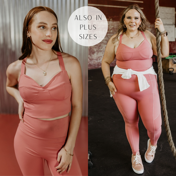 Models are wearing a mauve pink sports bra that has adjustable straps. Both models have it paired with matching leggings and gold jewelry.