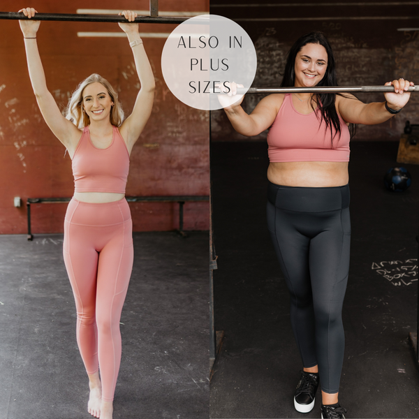 Both models are wearing a coral pink racer back sports bra. Size small model has it paired with matching coral leggings. Plus size model has it paired with black leggings and black sneakers.