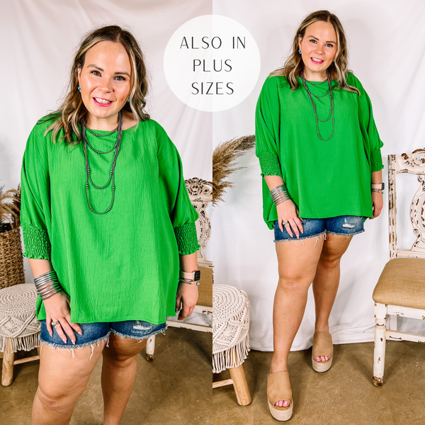 Model is wearing a bright green oversized top that has half sleeves. Model has it paired with tan wedges, distressed denim shorts, and silver jewelry.