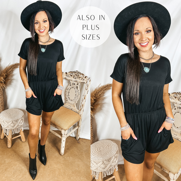 Model is wearing a black short sleeve romper. Model has it paired with a black hat, black booties, and silver jewelry.