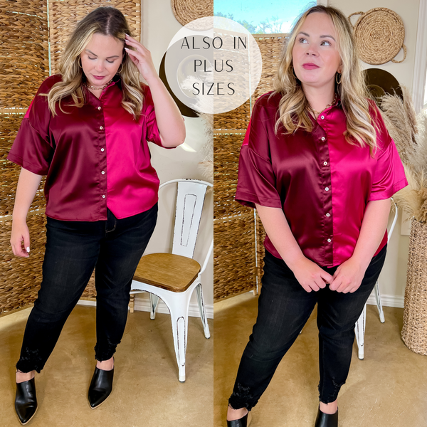 Model is wearing a half maroon and half fuchsia pink button up satin top with a collared neckline. Model has it paired with black pants, black booties, and gold jewelry.