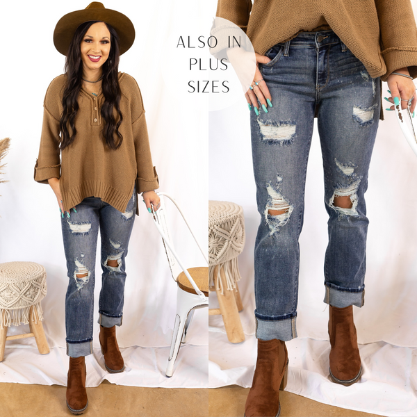Model is wearing a pair of distressed boyfriend jeans that are cuffed at the ankle. Model has it paired with a brown sweater, brown hat, and brown booties.