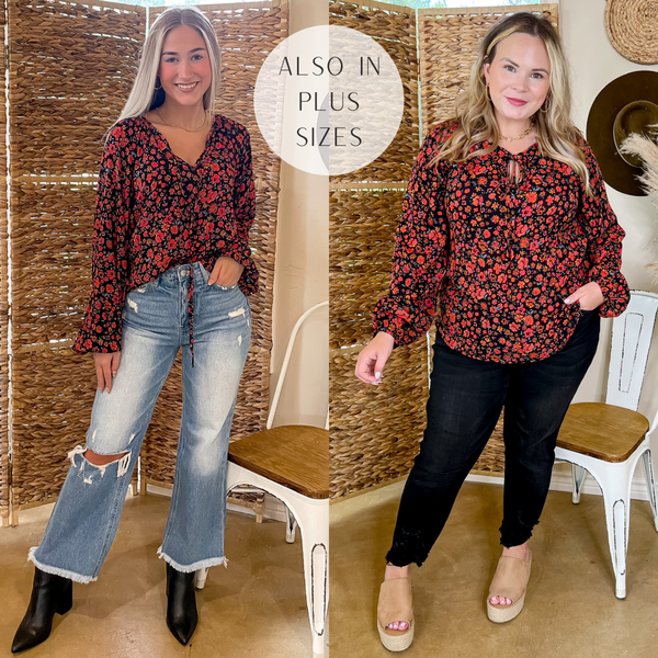 Models are wearing a black long sleeve top with a red floral print and a front tie keyhole. Size small model has it paired with distressed jeans, black booties, and gold jewelry. Size large model has it paired with black skinny jeans, tan wedges, and gold jewelry.