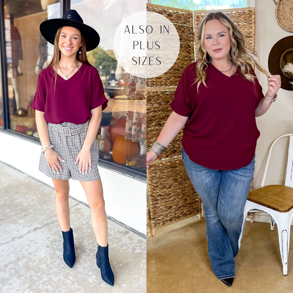 Models are wearing a maroon top that has short sleeves and a v neckline. Size small model has it paired with plaid shorts, black booties, and a black felt hat. Size large model has it paired  with bootcut jeans, black booties, and silver jewelry.