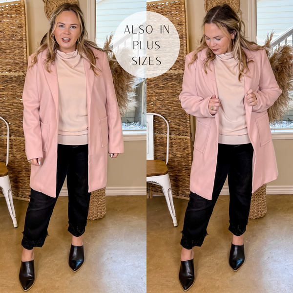 Model is wearing an open front long hot pink coat. Model has this collared coat paired with a beige top, black jeans, black mules, and gold jewelry.