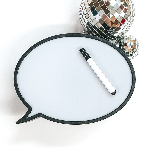 Black outlined speech bubble whiteboard. This whiteboard has a marker pictured on top. This is all pictured on a white background with disco balls at the top right corner. 